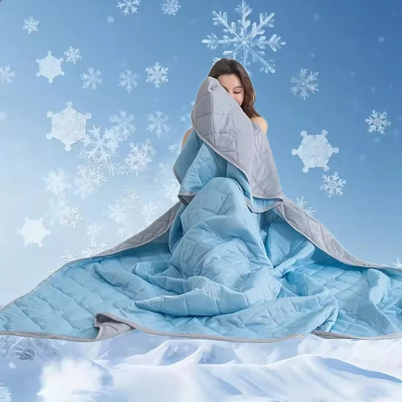 Person wrapped in a large blue and gray blanket with snowflake decorations on a blue background