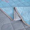 Close-up of a quilted fabric with light blue and gray colors.