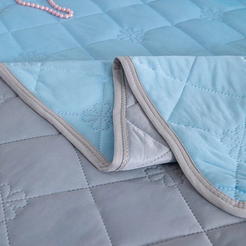 Close-up of a quilted fabric with light blue and gray colors.